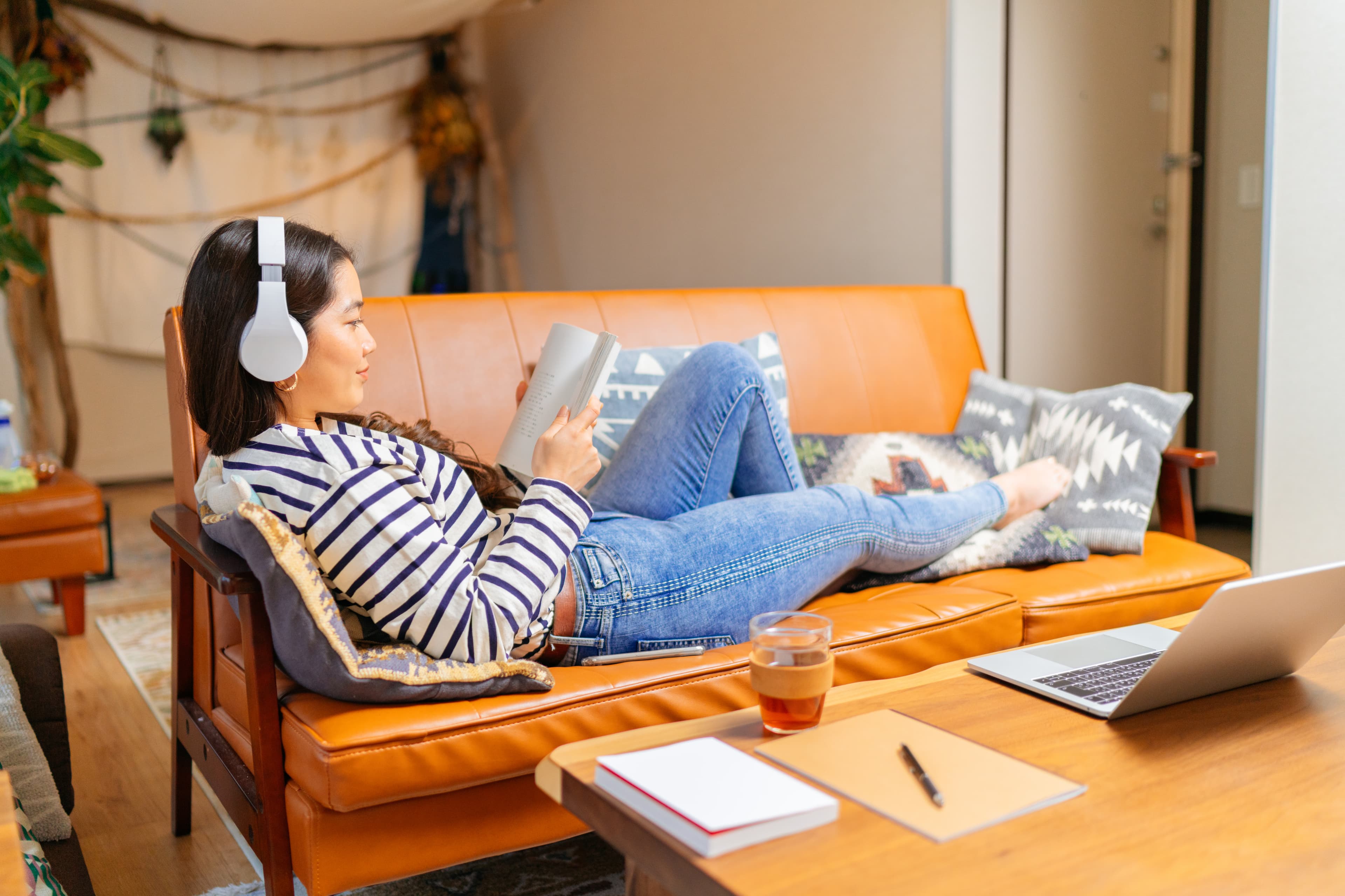 A student comfortably lying on a couch reading and relaxing